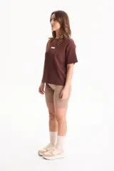Remera de algodón amarilla de manga corta, con corte suelto y pequeño aplique rectangular en el pecho.