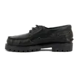 Zapato náutico de cuero negro con cordones, suela de goma track y detalle de etiqueta con logo "Country" en el lateral.