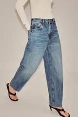 Jeans de tiro alto con corte tapered y largo al tobillo. Presenta cinco bolsillos, trabillas en la cintura, cierre frontal con cremallera y botón, y detalle de raya planchada en el delantero.