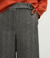 Pantalón de vestir de corte recto y tiro alto, confeccionado en tejido gris con textura tipo espiga. Presenta un diseño clásico con cierre frontal y trabillas para cinturón.