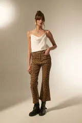 Pantalon jean de tiro alto con corte flare y ruedo desflecado, estampado con diseño animal print de leopardo en tonos marrones.