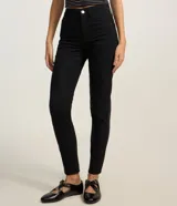 Pantalón skinny de sarga en color negro, con cintura mediana, trabillas, cierre delantero con botón y cremallera, y bolsillos funcionales al frente y en la espalda.