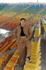 Pantalón camel de gabardina elastizada, corte sastrero, tiro bajo, con bolsillos delanteros, botón metálico y tajo en el lateral interno.