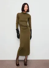 Vestido midi de punto fino color verde militar, con cuello perkins, manga larga y diseño entallado con fruncidos laterales.