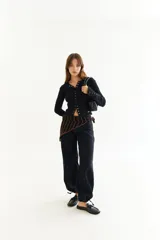 Top de manga larga color amarillo, confeccionado en tejido acanalado con cierre frontal de botones a presión metálicos. Presenta detalles de botones en los puños y un corte ajustado al cuerpo.