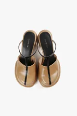 Mules de cuero color blanco con diseño moderno, taco ancho y plataforma. Cuenta con una tira superior negra que aporta estabilidad y un calce cómodo.