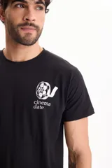 Remera de algodón negra, de manga corta, con cuello redondo y diseño estampado en el pecho con la inscripción 'cinema date' y un logo gráfico.
