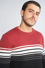 Sweater de punto con diseño de bloques de color, presentando una sección superior roja, una franja central con rayas horizontales en blanco, negro y gris, y una sección inferior negra. Posee cuello redondo, mangas largas y logo bordado en el pecho.