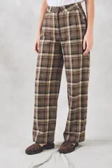 Pantalón de corte recto y tiro medio con estampado de cuadros escoceses en tonos marrones y beige. Presenta cierre frontal con botón y bolsillos laterales.