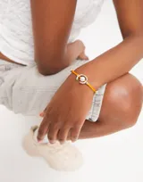 Pulsera de hilo color naranja con perla y fornitura bañada en plata de ley.