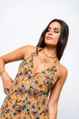 Vestido largo color ocre con estampado floral, escote en V y espalda descubierta.