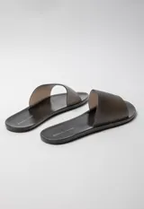 Sandalia chata color negro de goma semi transparente con tira ancha sobre el empeine.