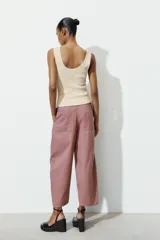 Pantalón de tiro alto con diseño tipo ballon, bolsillos laterales ocultos en costura y cierre frontal con cremallera y botón.