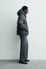 Cazadora acolchada tipo puffer de corte regular, confeccionada en tejido técnico repelente al agua. Cuenta con cuello subido, capucha ajustable y desmontable, cierre frontal con cremallera, bolsillos laterales con cremallera oculta y puños ajustables con tira adherente.