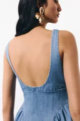 Vestido midi de denim suave, color azul claro, con escote cuadrado, espalda escotada y tirantes anchos. Presenta un cuerpo ajustado y una falda acampanada con frunces en las caderas que aportan volumen.