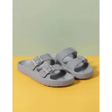 Sandalias chancletas de goma color beige con diseño texturizado en la suela, doble tira ajustable con hebillas y estilo slip-on.