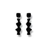 Aros colgantes negros con forma geométrica irregular.