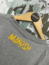 Remera gris con estampado amarillo de la palabra "OPPAI" con un diseño que simula senos.