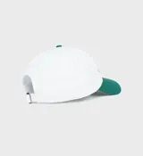 Gorro de béisbol blanco con visera verde y logo bordado en verde con la frase "Health is Wealth!".