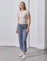 Pantalón jogger color crema, de corte ancho, con pretina elastizada y lazo de ajuste.