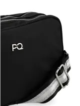 Bandolera rectangular negra con cierre superior y herrajes metálicos plateados. Incluye correa ajustable estampada en blanco y negro y aplicación de logo metálico frontal.