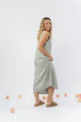 Vestido largo de lino con escote en V, diseño recto y fluido, con cierre frontal abotonado mediante botones de madera.