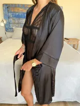 Bata corta de satén color negro con mangas 3/4 y lazo para ajustar en la cintura.