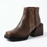 Bota corta de cuero vacuno color marrón, con diseño de paneles combinados en cuero liso y cuero texturizado. Presenta una puntera cuadrada, plataforma delantera y un taco geométrico ancho de altura media.