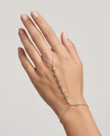 Pulsera de plata conectada a un anillo de dedo, decorada con circonias engastadas a lo largo de la cadena central.
