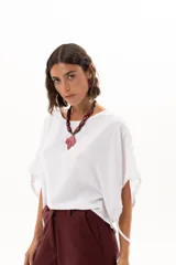 Blusa blanca de corte holgado y diseño minimalista, con mangas cortas tipo murciélago que presentan un detalle de fruncido lateral con cordón ajustable.