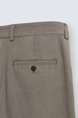 Pantalón chino de corte slim fit, confeccionado en tejido elástico. Presenta bolsillos frontales, bolsillos traseros de vivo con botón y cierre frontal con cremallera y botón.