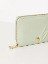 Billetera pequeña color bordó de cuero vacuno graneado con cierre de cremallera y logo de marca gofrado en el frente.