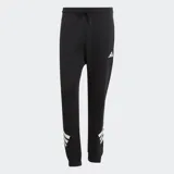 Pantalón deportivo Adidas de corte cónico, color negro con las icónicas tres tiras blancas en la parte inferior de una de las piernas y logo de la marca en el muslo. Cuenta con cintura elástica con cordón ajustable y puños acanalados.