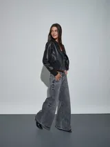 Campera bomber de eco cuero negro, con cierre frontal plateado, cuello, puños y cintura elastizados en rib.