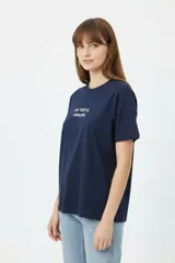 Remera negra de algodón con cuello redondo, manga corta y estampa frontal con texto en blanco.