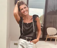 Top negro con lunares dorados, escote cuadrado, breteles anchos con volados y ribete blanco.