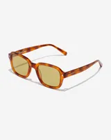 Lentes de sol unisex con armazón de acetato en tono carey y cristales amarillos. Presentan un diseño de marco cuadrado con detalles metálicos en las esquinas y la firma de Manuel Turizo en el interior de la patilla.