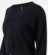 Suéter de punto color negro con escote en V estructurado, mangas largas y puños ajustados. Presenta un corte regular y tejido de tacto suave.