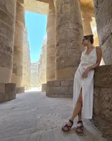 Collar con dije colgante de forma orgánica e irregular, acabado dorado, suspendido de un cordón negro de algodón natural.