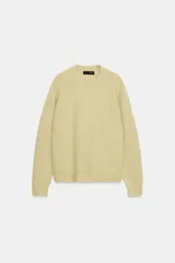 Jersey de punto color amarillo claro, con cuello redondo y manga larga. Diseño de corte clásico y textura suave.