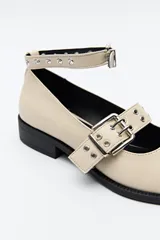 Zuecos de charol color borgoña con punta fina, correa al tobillo y doble tira sobre el empeine con hebillas metálicas plateadas.