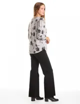 Buzo de tejido soft estampado, con cuello a la base y mangas largas con terminación fruncida. Presenta un diseño floral en tonos oscuros sobre base gris.