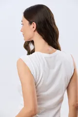 Musculosa de algodón color beige, de corte clásico con cuello redondo y diseño liso.