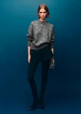 Sweater de punto fino color gris con cuello redondo, manga larga y diseño decorado con cristales brillantes distribuidos por toda la prenda.