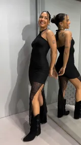 Vestido largo negro con cuello halter, cuerpo ajustado de tela texturizada y falda larga semitransparente de encaje.