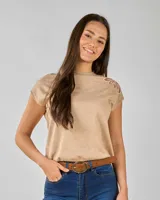 Blusa color beige de punto, manga corta y detalle de flor en tul en el hombro izquierdo.