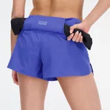 Short deportivo azul con logo reflectivo de New Balance en la pierna izquierda.