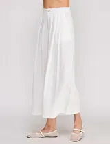 Pantalón palazzo de lino y viscosa, color blanco, de tiro alto y silueta amplia. Presenta pinzas frontales, bolsillos laterales y cierre con botón.