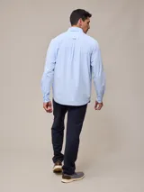 Camisa de manga larga para hombre, confeccionada en algodón con efecto peach (textura suave). Presenta un estampado de cuadros vichy en tonos azul marino y blanco, cuello con botones y un bolsillo de parche en el pecho izquierdo.