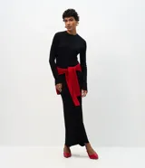 Vestido midi de punto acanalado, color negro, con cuello redondo y mangas largas. Confeccionado en tejido de viscosa y poliamida, presenta un diseño ajustado y estructurado.